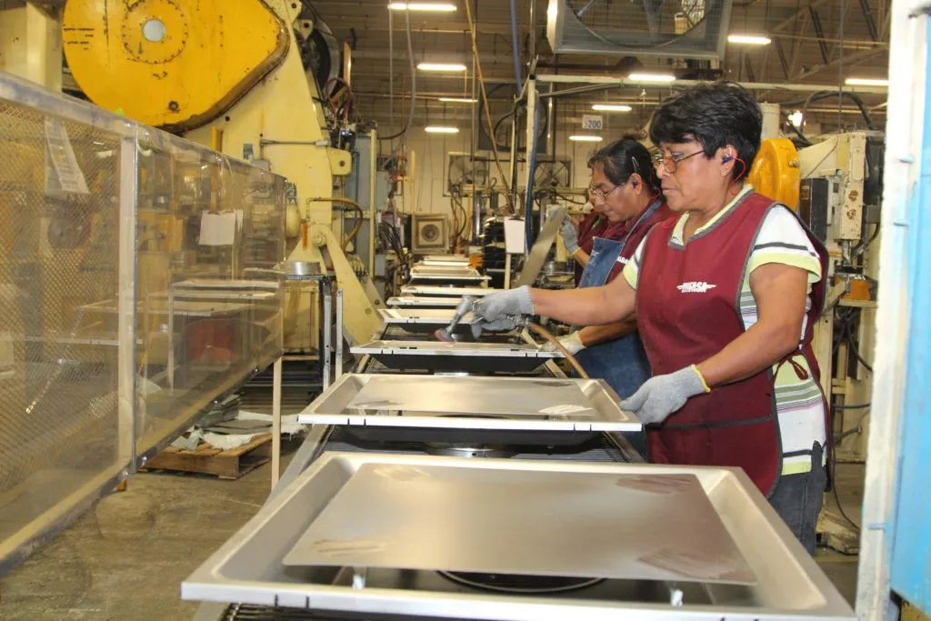 Ramona Morales (foreground) works on an assembly line with Romualda Hernandez Domingo.