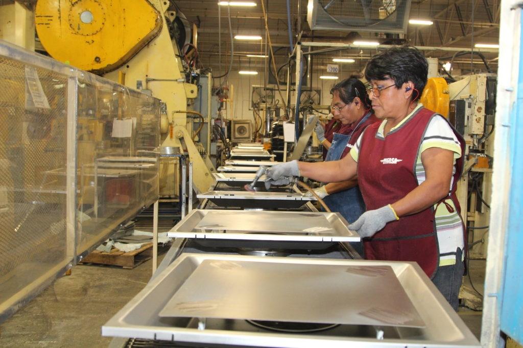 Ramona Morales (foreground) works on an assembly line with Romualda Hernandez Domingo.
