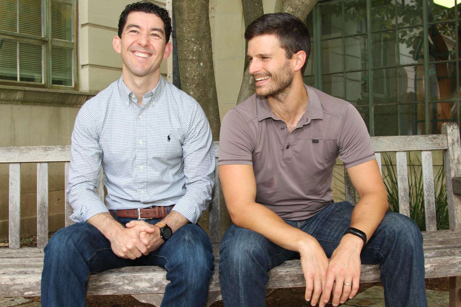 Todd Davidson and Josh Rhodes on a bench on UT campus