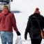 Storm Uri photo of people walking on snow covered street, wearing only a hoodie in temperatures well below freezing