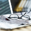 glasses sitting on a desk in front of an open laptop