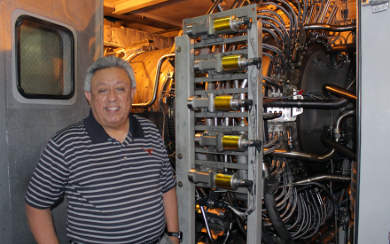 Juan Ontiveros stands in front of power plant equipment